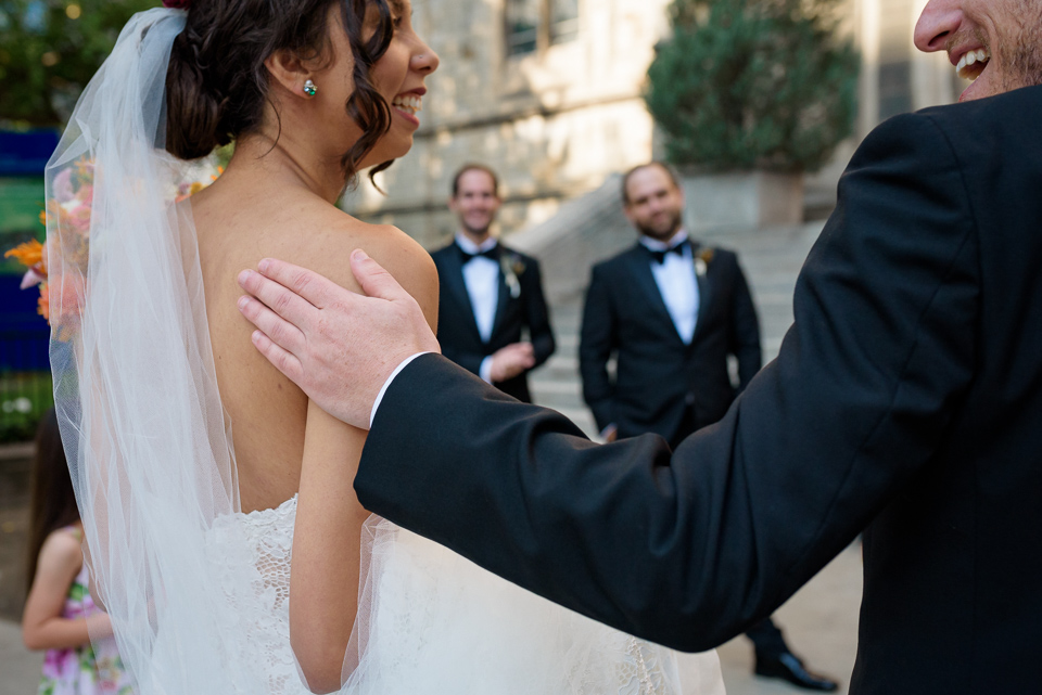 Close up of groom's hand on bride's shoulder