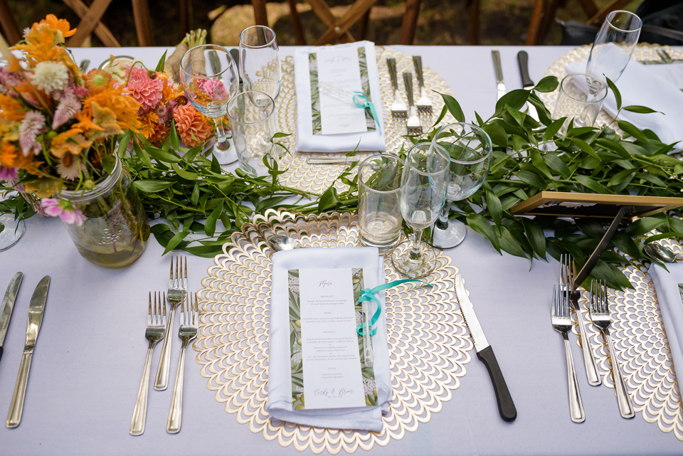 Table setting with menu, small vial of bubbles, and floral arrangements
