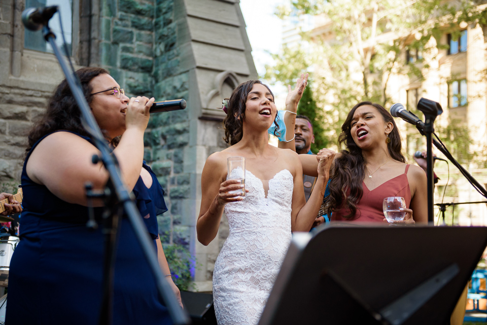 Bride singing on stage with her sister and cousin