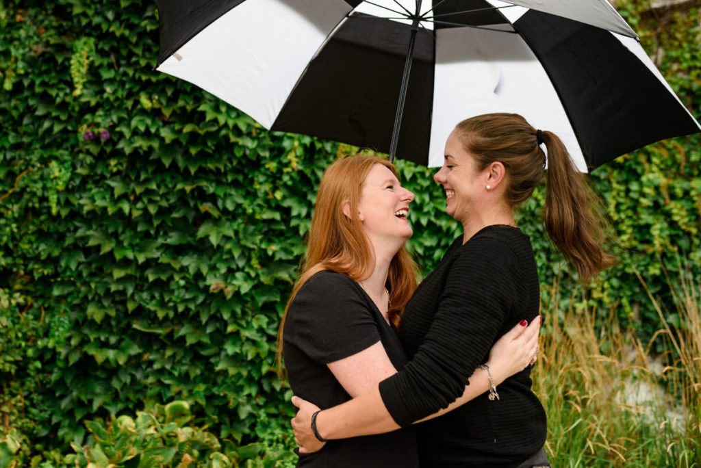 Couple laughing together under an umbrella