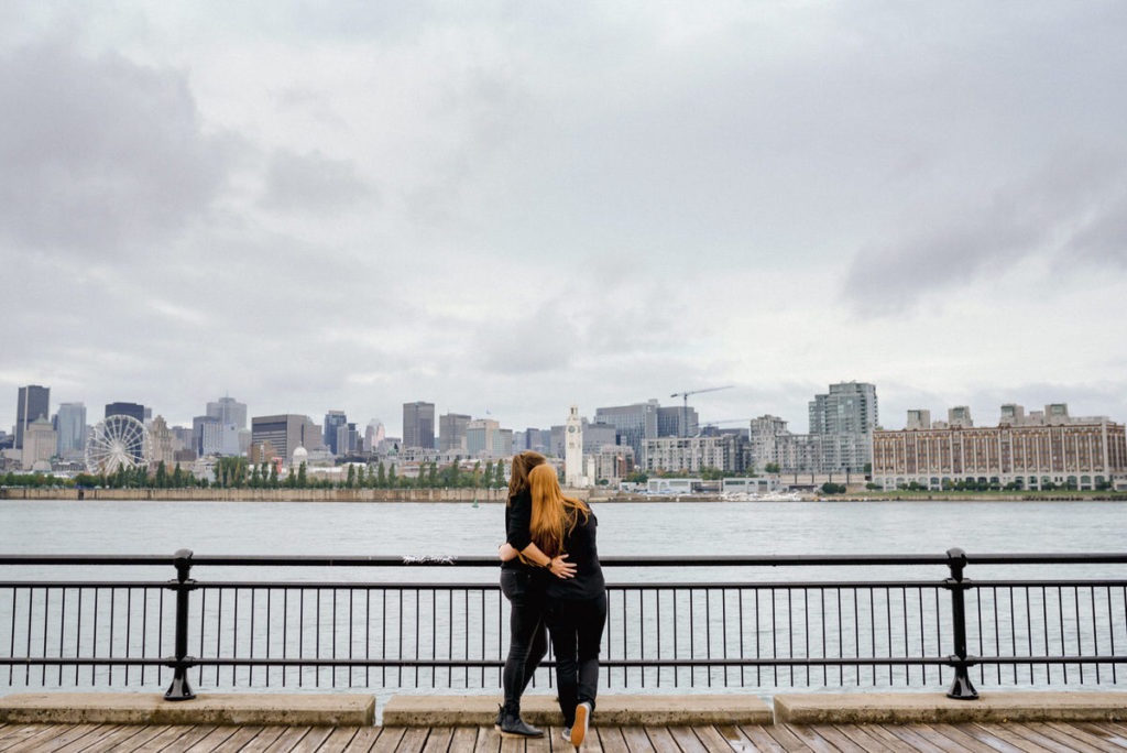 Two women hugging and watching the view of Montreal from Parc Jean-Drapeau
